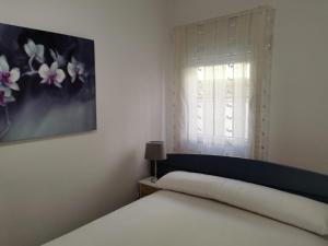 a white bedroom with a bed and a window at Bajo al lado del Ayuntamiento in Santander