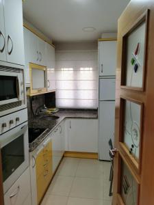 a kitchen with white cabinets and a microwave at Bajo al lado del Ayuntamiento in Santander