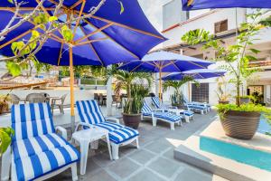 巴亞爾塔港的住宿－Hotel Pueblito Vallarta，庭院里一排蓝色的椅子和遮阳伞