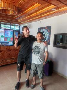 Dos hombres posando para una foto en una habitación en Dream Valley Home Stay en Kasol