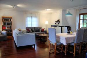 ein Wohnzimmer mit einem Sofa, einem Tisch und Stühlen in der Unterkunft Casa Vaqueiro Llanes in Llanes
