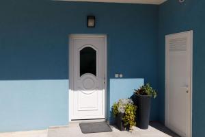 une chambre bleue avec une porte blanche et quelques plantes dans l'établissement Blue home, à Makarska