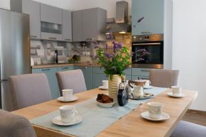 a table with cups and saucers on it in a kitchen at Blue home in Makarska