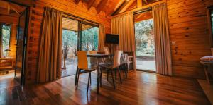 a dining room with a table and chairs and large windows at Irová Apart Hotel in Posadas