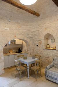 una cucina e una sala da pranzo con tavolo e sedie di Trullo A Casedd ad Alberobello