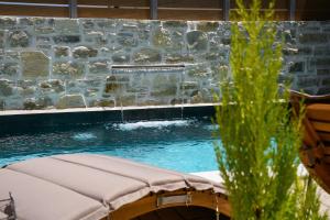 una piscina con una pared de piedra y cascadas en Villa Privilege Kalamaki en Kalamaki
