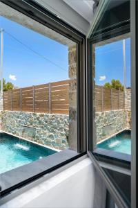 a window with a view of a swimming pool at Villa Privilege Kalamaki in Kalamaki Heraklion +33 photos