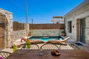 een patio met een tafel en stoelen en een zwembad bij Villa Privilege Kalamaki in Kalamaki