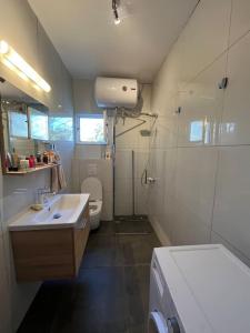 a bathroom with a shower and a sink and a toilet at Seaside Cottage with Garden in Golem