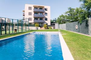 a swimming pool in front of a building at Pierre & Vacances Torredembarra in Torredembarra