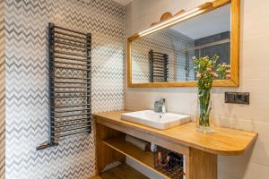 ein Badezimmer mit Waschbecken und Spiegel in der Unterkunft Poza Szlakiem in Zakopane + 20 Fotos