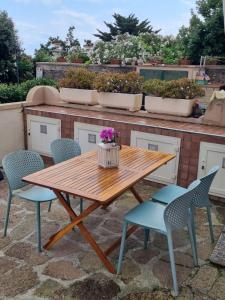 una mesa de madera y sillas en un patio en Le petit refuge, en Capraia