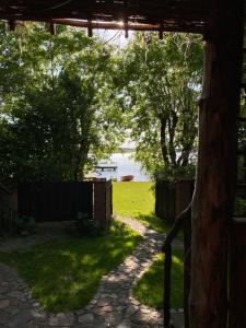 een uitzicht op een achtertuin met een hek en een tuin bij Domek z prywatną plażą i sauną in Mikołajki
