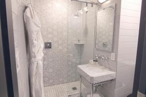a white bathroom with a sink and a shower at Hotel Edison Times Square in New York