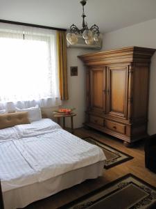 a bedroom with a large bed and a wooden cabinet at Zrínyi ház in Szántód