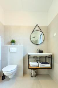 a bathroom with a white toilet and a mirror at Apartments La Scogliera Rovinj in Rovinj