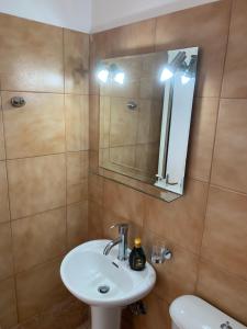 uma casa de banho com um lavatório e um espelho em ΜΕΤΑΧΑ em Mikros Gialos