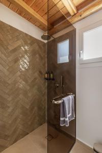 a bathroom with a glass shower with a sink at Aya Sofia Suites in Mikonos