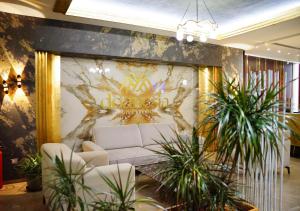 a lobby with a white couch and some plants at Doanesia Premium Hotel & Spa in Tirana