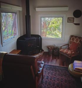 a living room with a wood stove and a couch at Gum Grove Chalets in Denmark