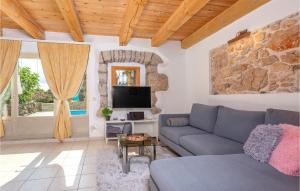 a living room with a couch and a tv at Beautiful Home In Krk With 2 Bedrooms, Wifi And Outdoor Swimming Pool in Garica