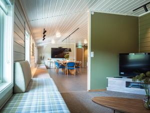 een woonkamer met een tafel en een televisie bij Krokstrand Fjellpark AS in Storforshei