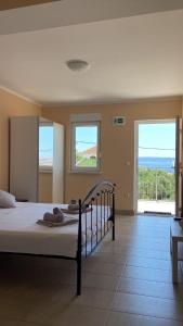 a bedroom with a bed with a view of the ocean at Apartmani Lorena in Okrug Gornji