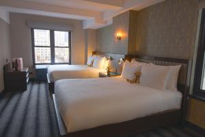 a hotel room with two beds and a window at Hotel Edison Times Square in New York
