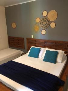 a bedroom with a large bed with blue pillows at chale aparecida dos milagres in São Miguel dos Milagres