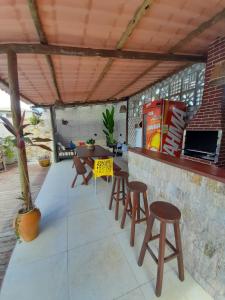 d'une terrasse avec un bar avec des tabourets et une table. dans l'établissement chale aparecida dos milagres, à São Miguel dos Milagres