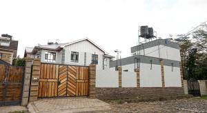 ein Haus mit einem Holztor und einem Zaun in der Unterkunft Advent Homes on Moi South lake road, Villa View Estate in Naivasha