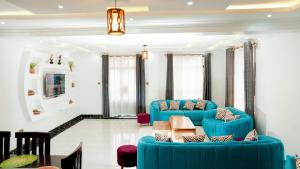 una sala de estar con 2 sofás azules y una mesa. en Advent Homes on Moi South lake road, Villa View Estate, en Naivasha