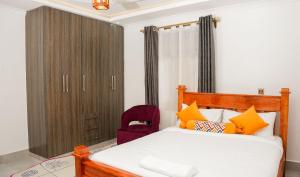 sypialnia z łóżkiem i czerwonym krzesłem w obiekcie Advent Homes on Moi South lake road, Villa View Estate w mieście Naivasha