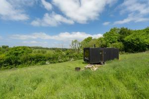 a black object in the middle of a field at Secluded Offgrid Cabin w/ Sunset View & Fireplace in Canterbury