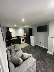 a living room with a couch and a kitchen at Royal Apartments in Thornaby on Tees