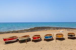 un grupo de barcos sentados en la playa en Eslanzarote ECO TANA HOUSE, super wifi, Tv satélite, Bbq en Playa Honda