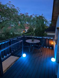 a patio with a table and chairs on a deck at LiMo Apartman in Fonyód