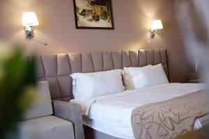 a bedroom with a large bed with white sheets and pillows at Doanesia Premium Hotel & Spa in Tirana