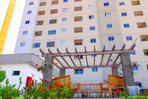 a building with a wooden pergola in front of it at Apartamento sofisticado, confortável e bem equipado - Loft Felau in Cuiabá