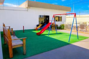a playground with a red slide and a bench at Apartamento sofisticado, confortável e bem equipado - Loft Felau in Cuiabá