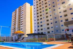 a swimming pool in front of two tall buildings at Apartamento sofisticado, confortável e bem equipado - Loft Felau in Cuiabá