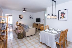 ein Esszimmer und ein Wohnzimmer mit Tisch und Stühlen in der Unterkunft Eslanzarote TANA HOUSE, super wifi, Tv satélite, Bbq in Playa Honda