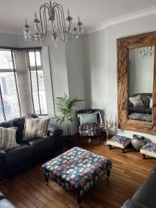 a living room with a couch and a large mirror at Adanhouse-stockland spacious 5 bedroom house sleeps 12 private garden in Cardiff