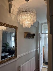 a hallway with a mirror and chandeliers at Adanhouse-stockland spacious 5 bedroom house sleeps 12 private garden in Cardiff