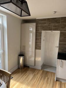 ein Wohnzimmer mit einem Kühlschrank und einer Tür in der Unterkunft Adanhouse-stockland spacious 5 bedroom house sleeps 12 private garden in Cardiff