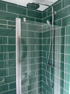 a green tiled shower with a shower head in a bathroom at Adan House - Stockland in Cardiff +76 photos