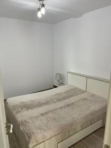 Dormitorio blanco con cama y pared blanca en Cosy place to stay, en Timisoara