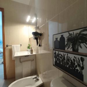 a bathroom with a white toilet and a sink at O POSTIGO in Praia da Vitória