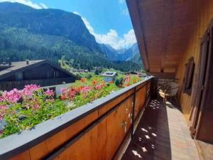 a balcony with flowers and a view of mountains at La Mansarda in the Dolomites Jacuzzi in Santo Stefano di Cadore