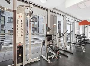 a gym with several treadmills and elliptical machines at Stunning 2BD Apartment on the 38th Floor in Midtown in New York